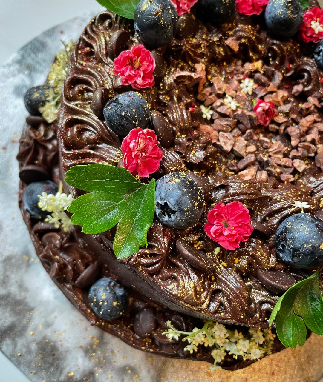 Eat Your Greens chocolate cake decorated with fruit and flowers