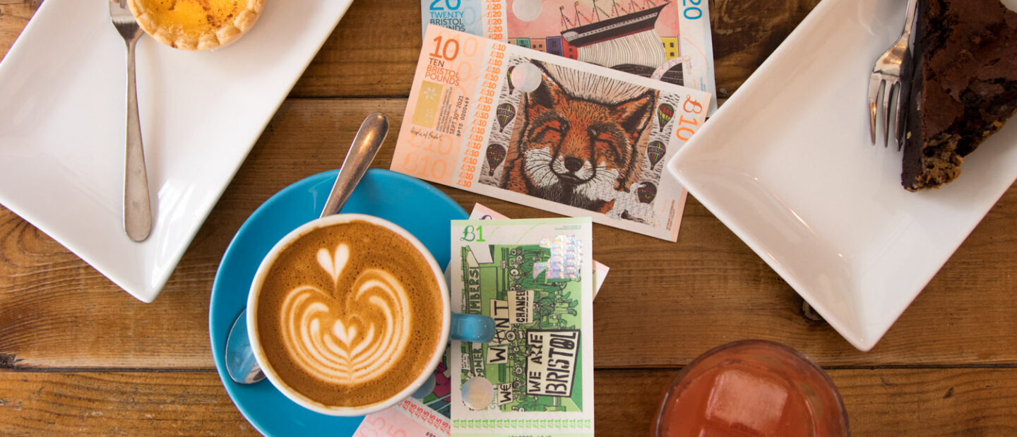 Bristol Pounds next to a cup of coffee