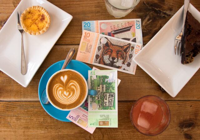 Bristol Pounds next to a cup of coffee